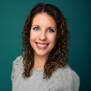 Female OB-GYN smiling in professional headshot.