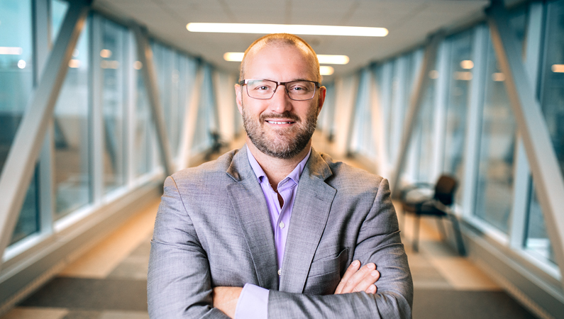 Man smiling in a well lit walkway.