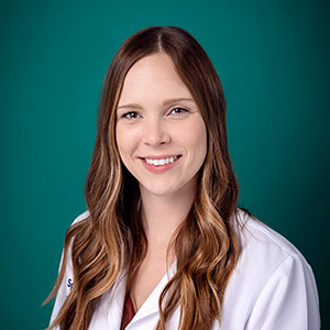 Female nurse practitioner smiling for professional headshot.
