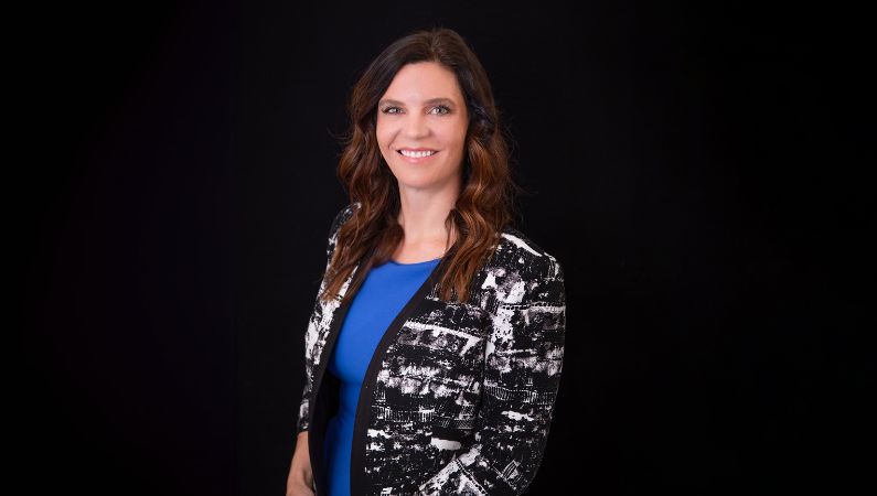 Female nurse practitioner posing in front of black background