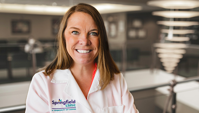 Woman smiling in a well lit lobby.