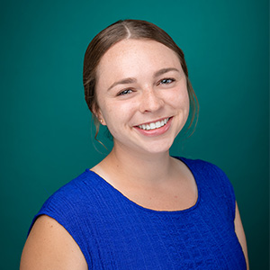 Female in blue shirt smiling for professional headshot.