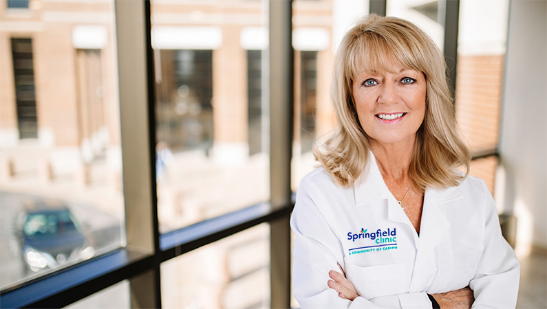Woman smiling in front of a window,