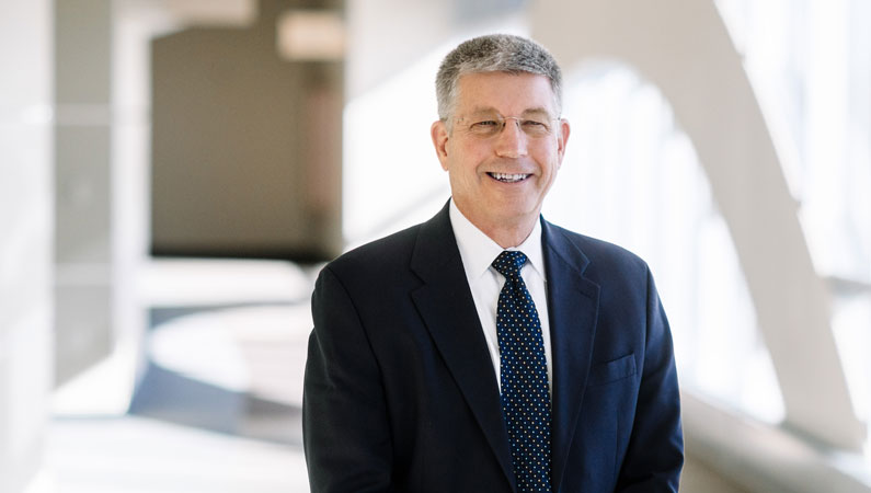 Man with glasses smiling wearing suit