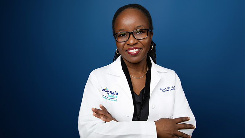 Female smiling in front of blue background