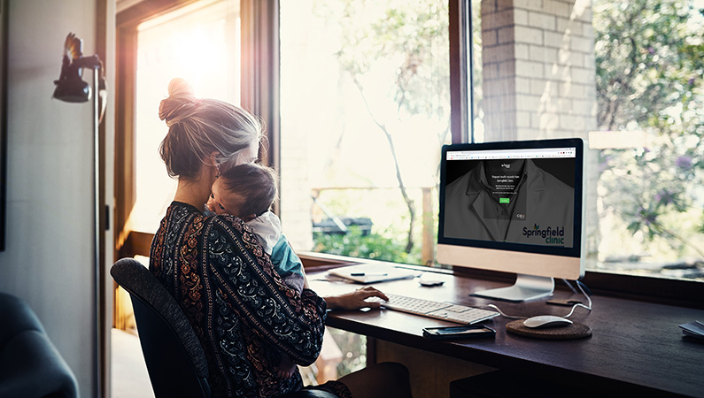 Female with young baby sitting at computer