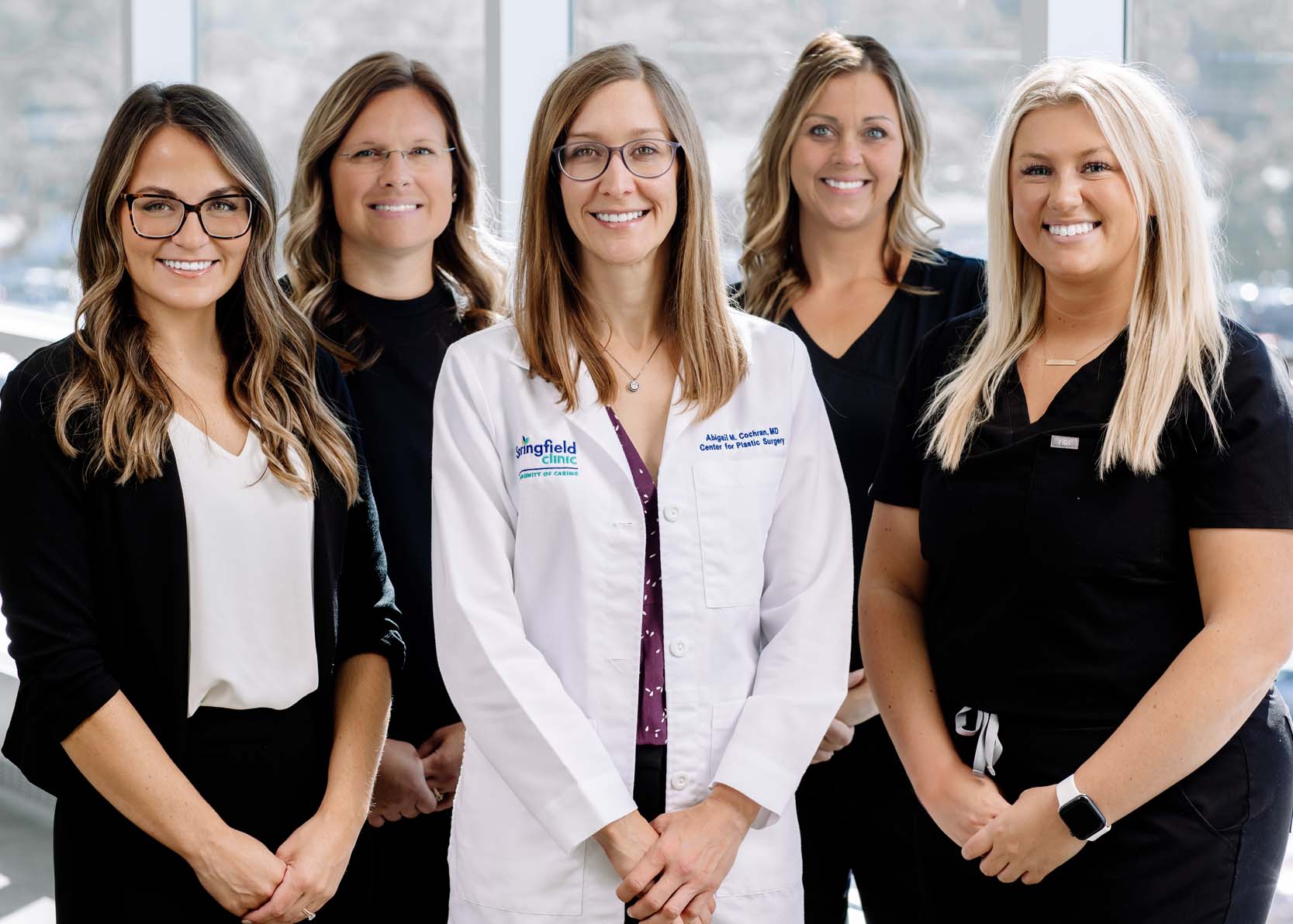 Female plastic surgery doctor standing with a group of female nurses.