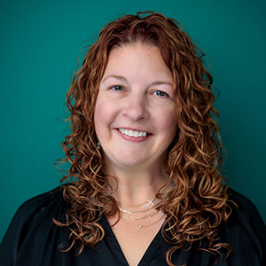 Female certified nurse midwife smiling in professional headshot.