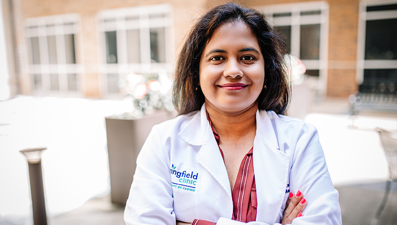 Woman smiling outside in front of the clinic.