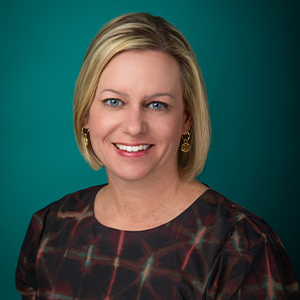 Female nurse practitioner smiling in professional headshot.