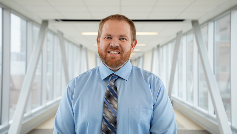 Dr. Fox smiling in a well lit walkway.