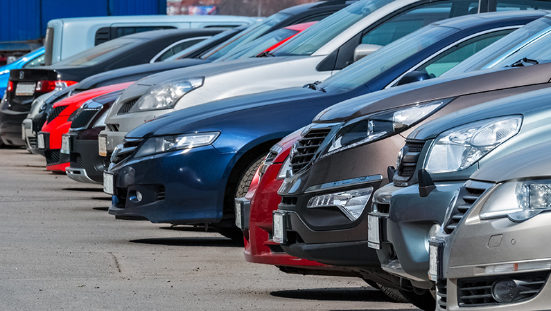 Several cars lined up in a parking lot.