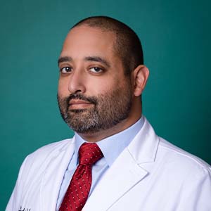 Male doctor in white coat professional headshot.