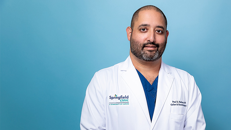 Male doctor in white coat posing for a professional headshot.