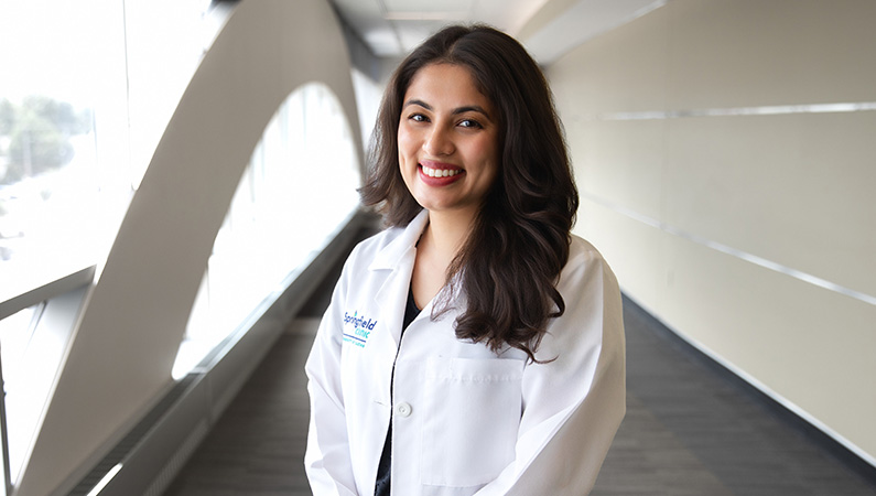 Female optometrist wearing white medical coat smiling in professional headshot