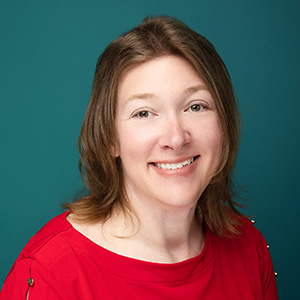 Female nurse practitioner smiling in professional headshot.