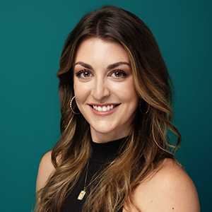 Female nurse practitioner smiling in professional headshot.