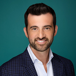 Male plastic surgeon smiling in professional headshot