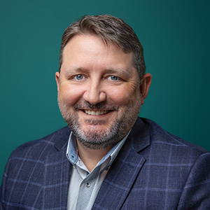 Male podiatrist smiling in professional headshot.