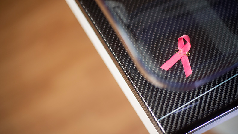 Imaging machine with small pink ribbon representing breast cancer