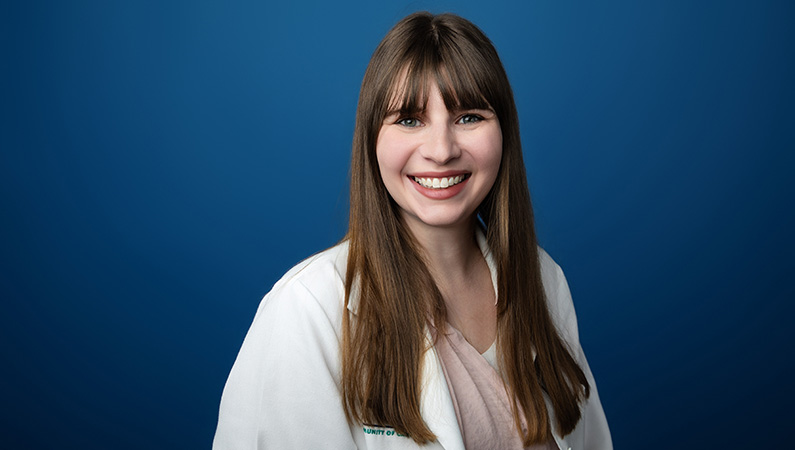 Female family medicine physician wearing white medical coat smiling.