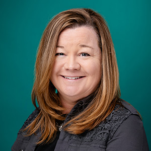Female nurse practitioner smiling in professional headshot.