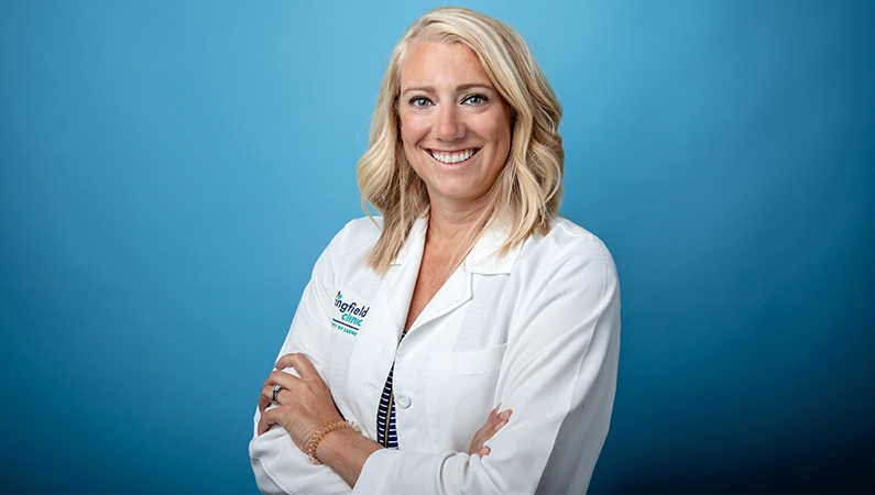 Female neurology nurse practitioner in white medical coat smiling for professional headshot.