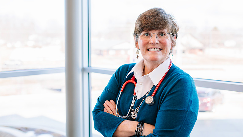 Woman smiling in front of a window.