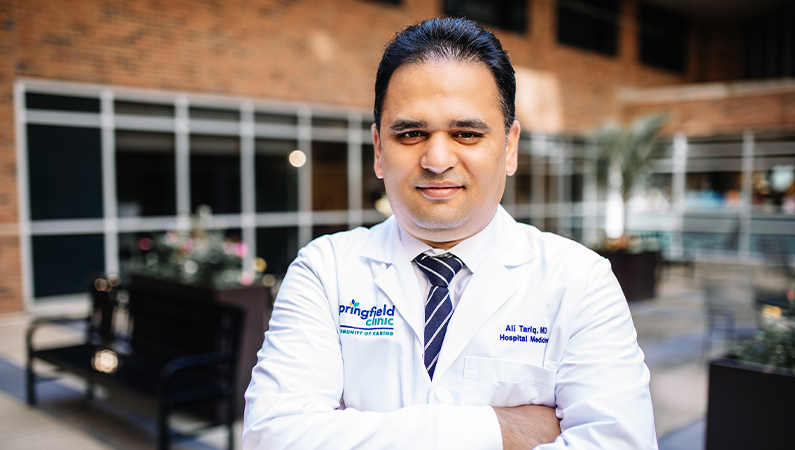 Man smiling outside in front of the clinic.