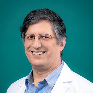 Male family medicine doctor smiling in professional headshot.