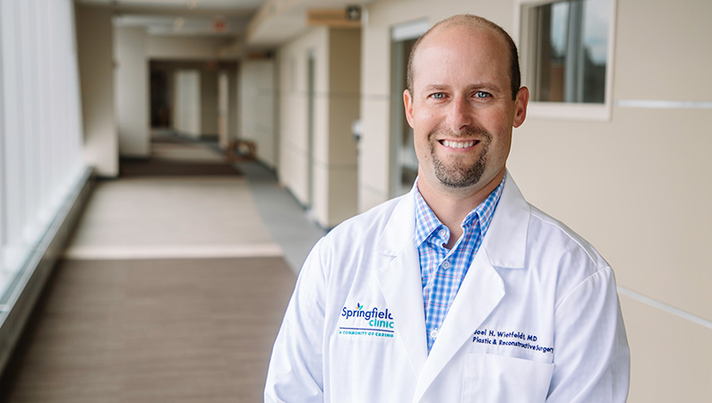 Man smiling in a well lit hallway.