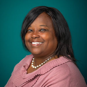 Female provider smiling in front of green background