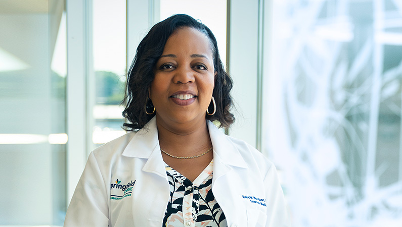 Woman smiling in front of a window.
