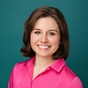 Female in front of blue background smiling