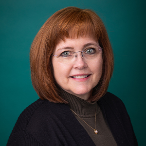 Female nurse practitioner smiling in professional headshot.